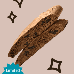 Close-up of two stacked Dee Dee's Dunkers biscotti sliced on a beige background highlighting the cherries inside
